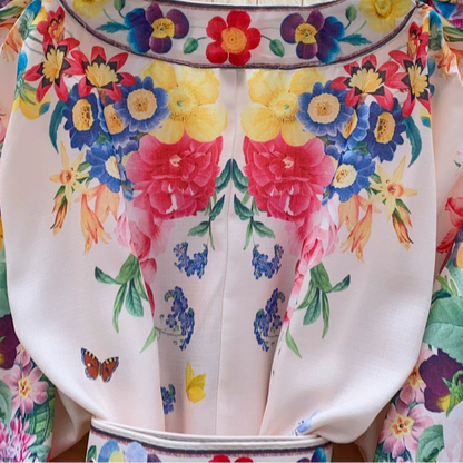 A floral mini dress with long puffed sleeves, a V-neckline, and a belt.