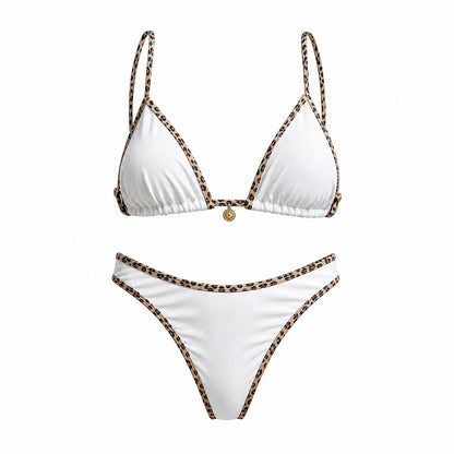 Flat lay of the Alessandra bikini set in black, white, and cream featuring leopard print contrast piping and a gold sun charm detail.