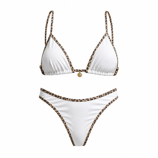 Flat lay of the Alessandra bikini set in black, white, and cream featuring leopard print contrast piping and a gold sun charm detail.