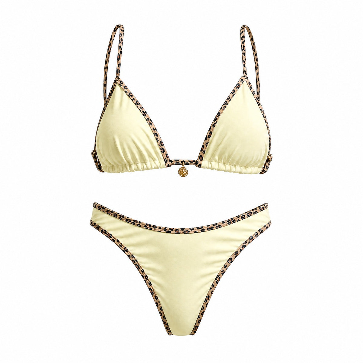 Flat lay of the Alessandra bikini set in black, white, and cream featuring leopard print contrast piping and a gold sun charm detail.