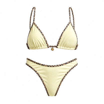 Flat lay of the Alessandra bikini set in black, white, and cream featuring leopard print contrast piping and a gold sun charm detail.