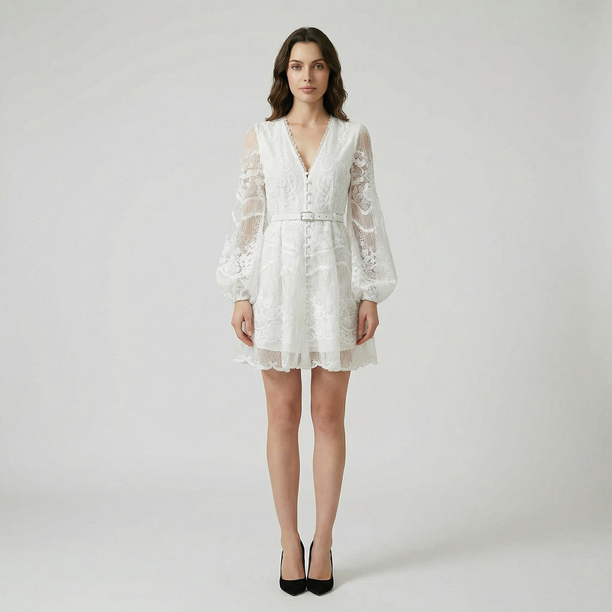 White floral lace mini dress with long puff sleeves and pearl buttons on a flat lay background
