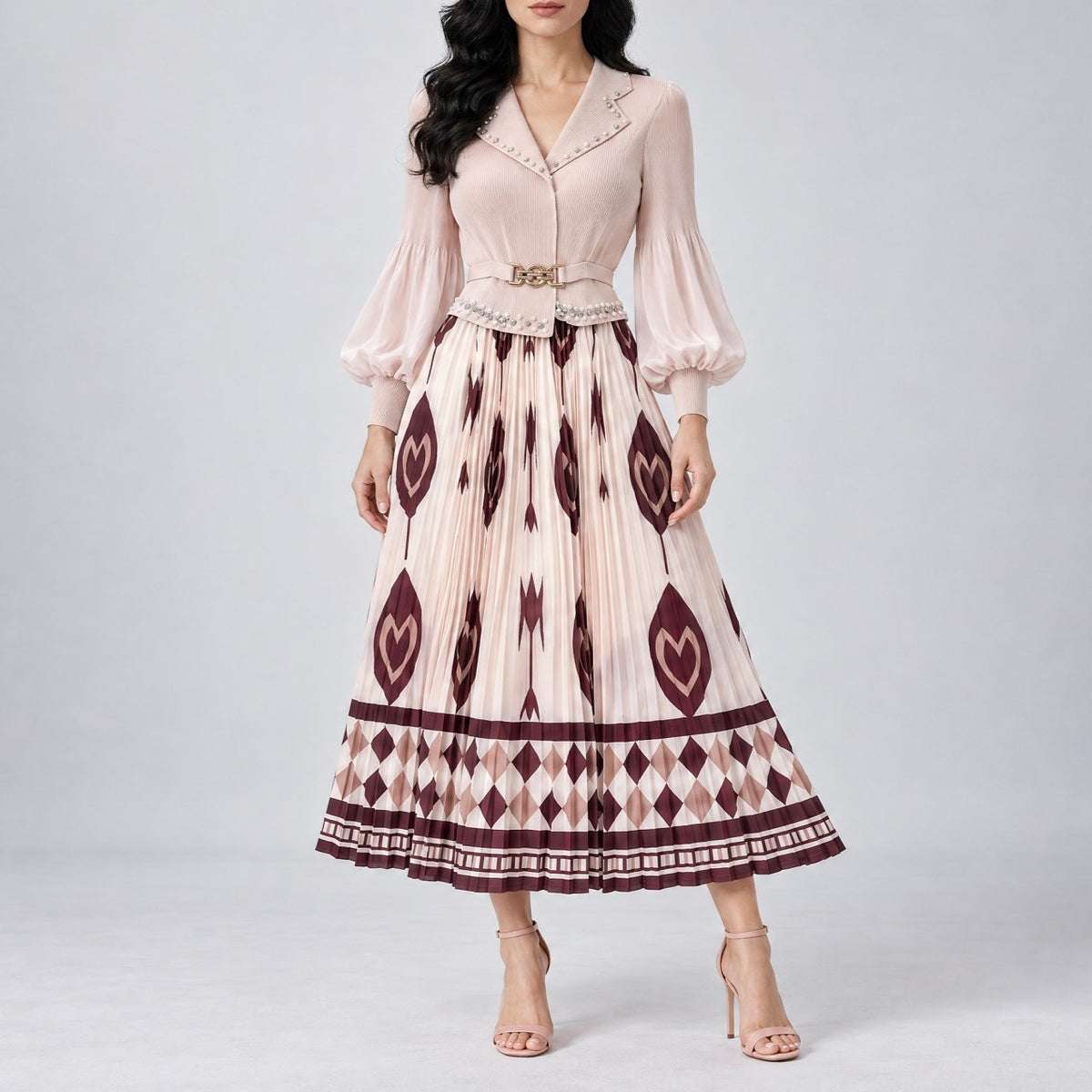 sleeve midi dress with a pleated skirt, featuring a cream base with dark burgundy geometric and ikat patterns, a matching belt, and a delicate embroidered neckline. Elegant pleated midi dress with a fitted bodice, belted waist, and patterned skirt