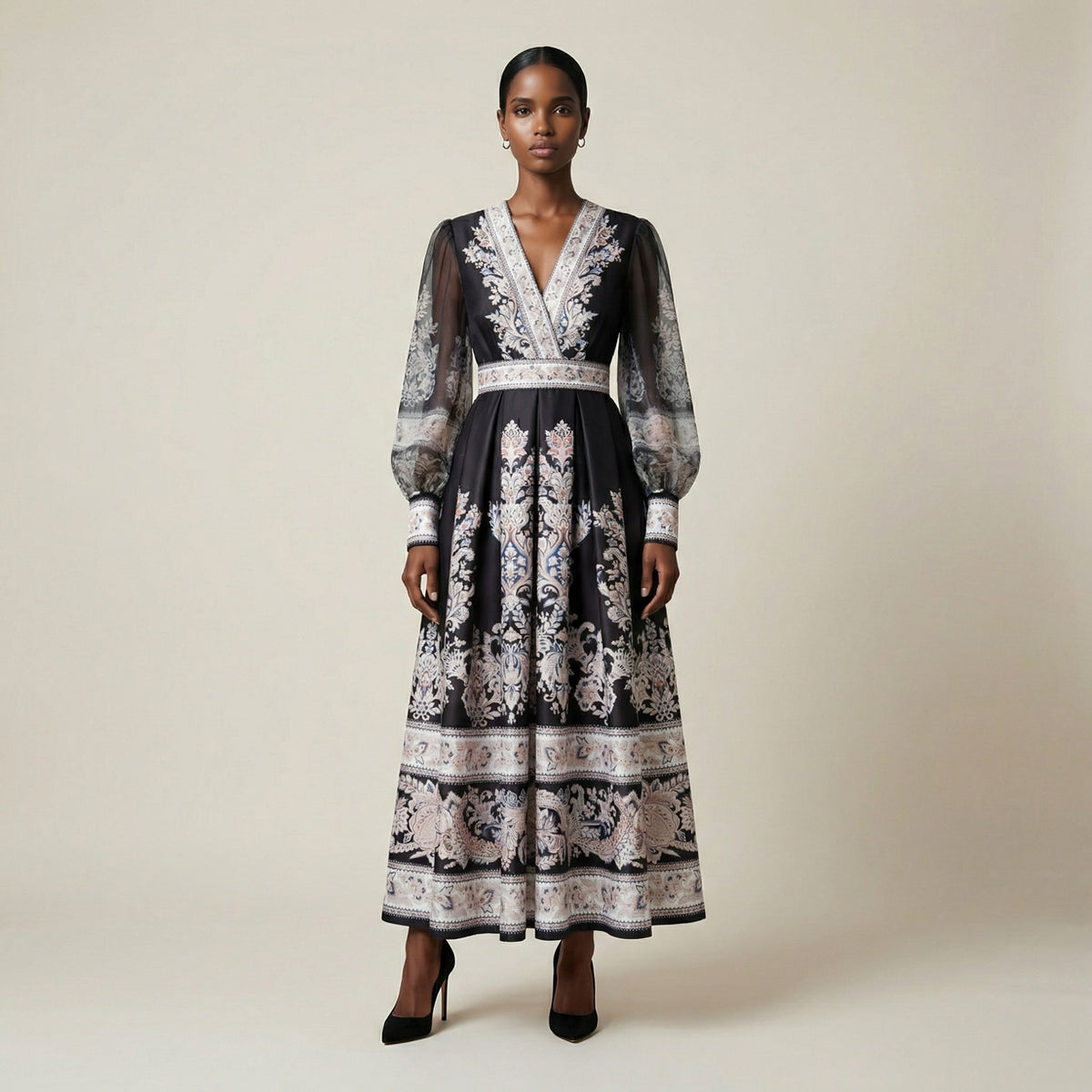 A woman modeling the Gabriella black ribbed knit maxi dress featuring a long-sleeve bodice and a side-pleated accordion skirt with a white and orange sunset ombré design.