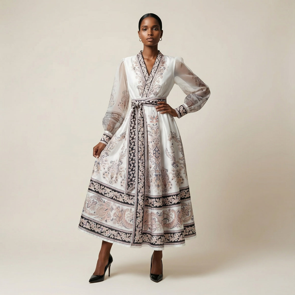 A woman modeling the Gabriella black ribbed knit maxi dress featuring a long-sleeve bodice and a side-pleated accordion skirt with a white and orange sunset ombré design.