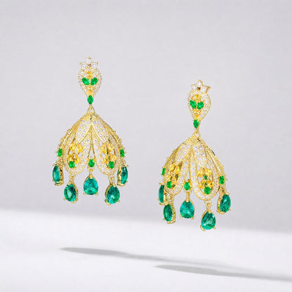 Pair of Georgia 5cm gold-toned dangle earrings featuring emerald green and white cubic zirconia stones in a water drop tassel design. statement earrings showcasing the intricate 3D dome structure and green teardrop stone tassels.