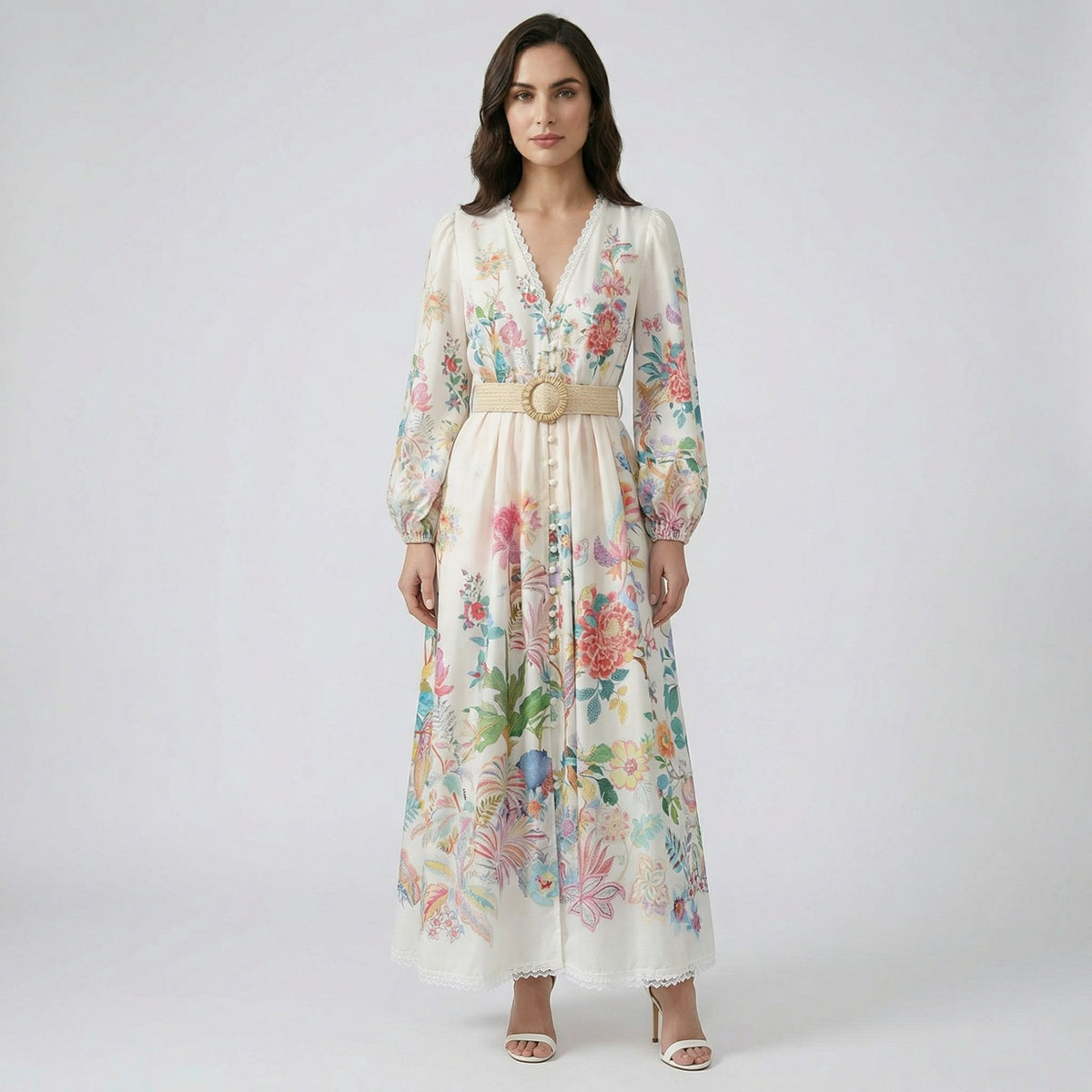 Full-length Hana floral maxi dress in cream with colorful botanical print, balloon sleeves, and woven straw belt.