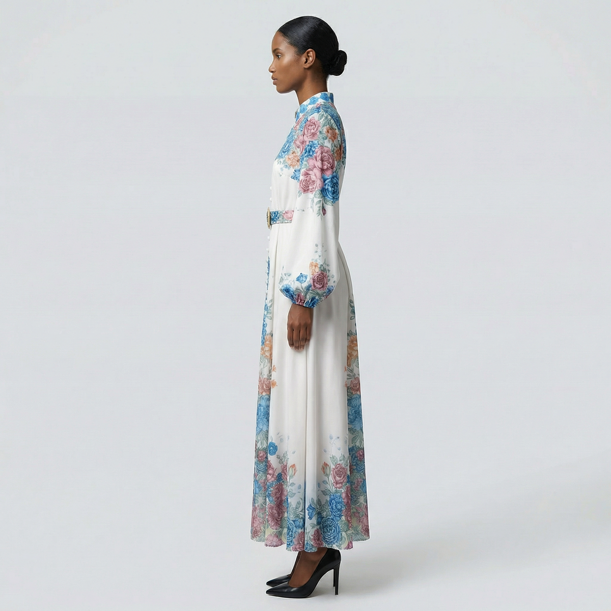 The Heba maxi dress in a 141 cm length featuring a long-sleeved ribbed knit bodice and a dramatic side-pleated accordion skirt with a matching waist belt.