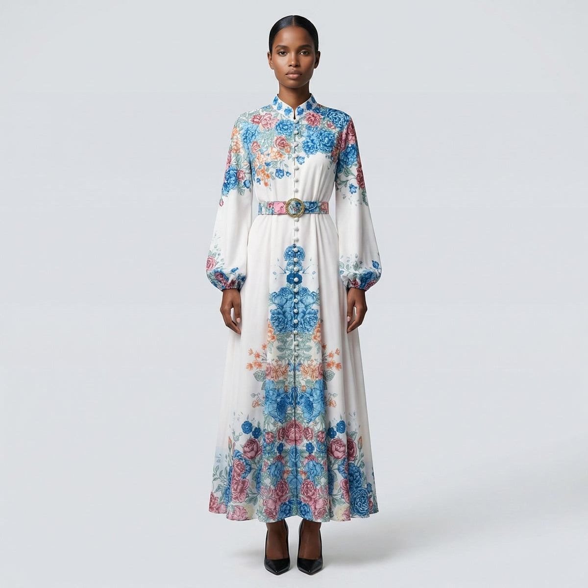 The Heba maxi dress in a 141 cm length featuring a long-sleeved ribbed knit bodice and a dramatic side-pleated accordion skirt with a matching waist belt.