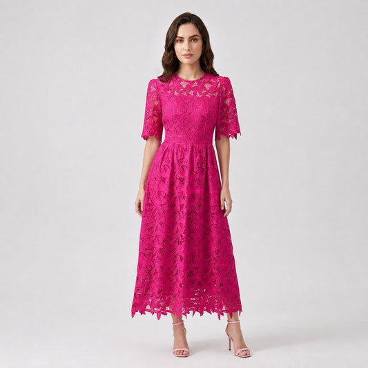 A woman modeling the Ionna Dress, a floor-length floral lace maxi dress with short sleeves, available in fuchsia pink, tangerine orange, and white. Occasion wear for weddings and daily life.Floral lace maxi dress.