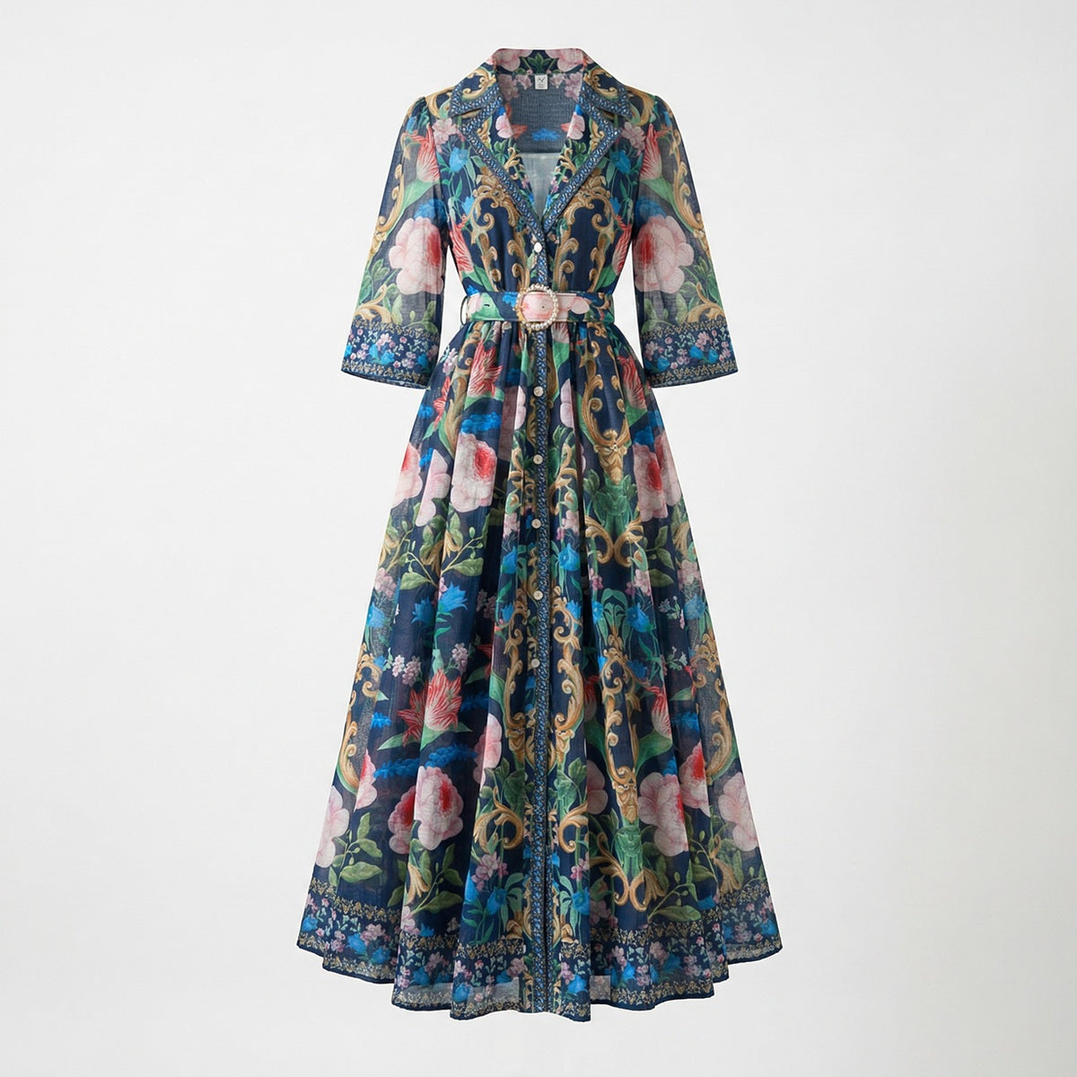 The Judith Maxi Dress in cream and navy featuring a floral baroque print, notched collar, button-down front, and a matching gold buckle belt on a flat lay display.
