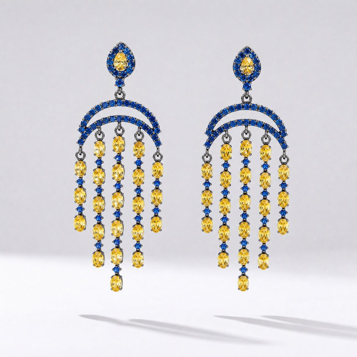 Pair of Leah geometric drop earrings featuring tiered blue and yellow cubic zirconia stones in a black gold setting.