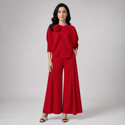 two-piece outfit featuring a button-up top with a 3D flower and wide-leg trousers.
