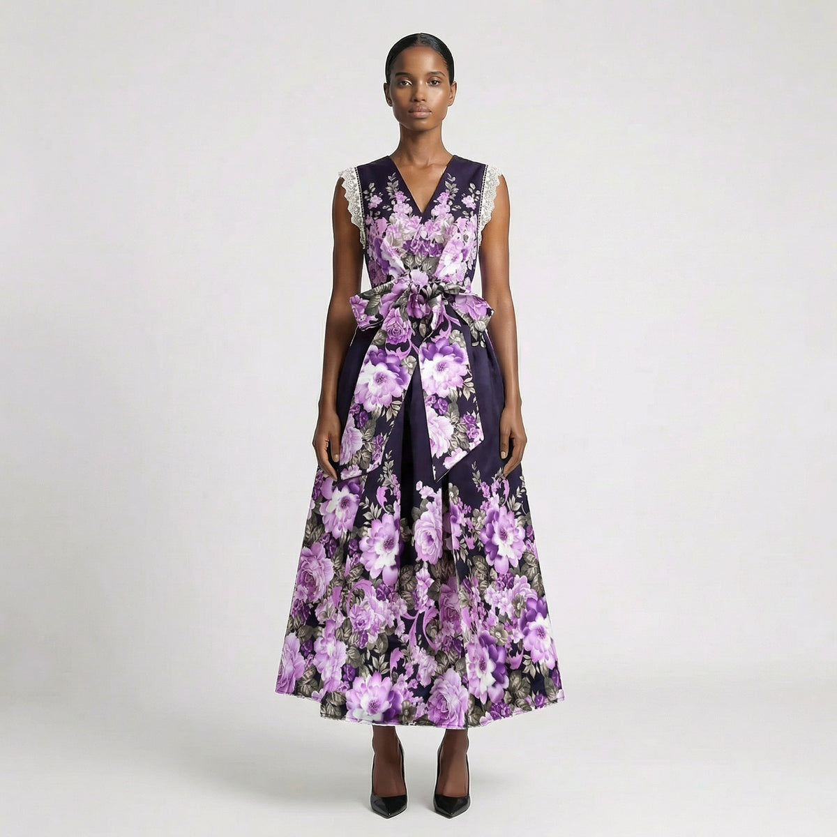 Lorelai floral print maxi dress in cream and purple featuring a v-neckline and large waist bow. Lorelai floral print maxi dress in black and purple with lace sleeve detailing and a full-length skirt.