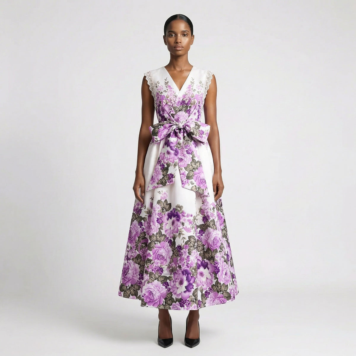 Lorelai floral print maxi dress in cream and purple featuring a v-neckline and large waist bow. Lorelai floral print maxi dress in black and purple with lace sleeve detailing and a full-length skirt.