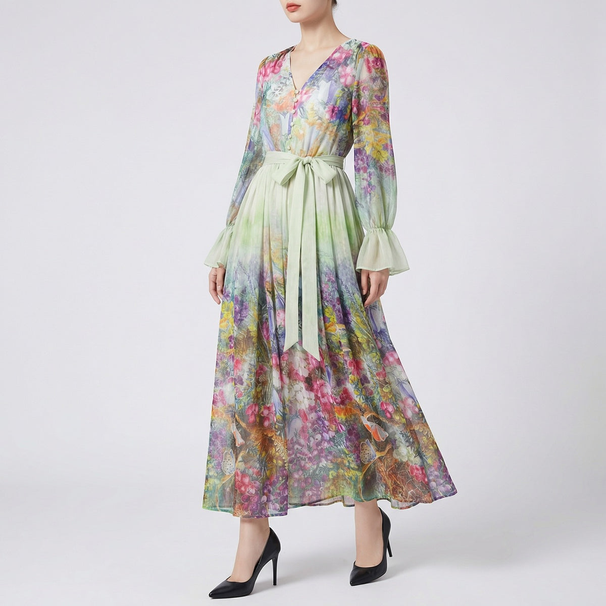 A two-piece set featuring a long-sleeved ruffle blouse and a 100cm matching botanical floral maxi skirt in sage green with a wide waist belt.
