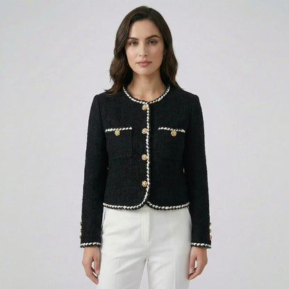 Flat lay of Louise black tweed jacket with white braided trim and gold floral buttons.
