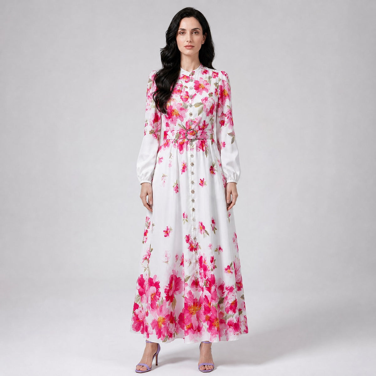 Louise Dress showcasing the vibrant pink floral placement motif along the hem and shoulders of the white maxi gown. Louise Dress, a blue and white floral maxi dress with a mock neck, button-down front, and a matching waist belt.