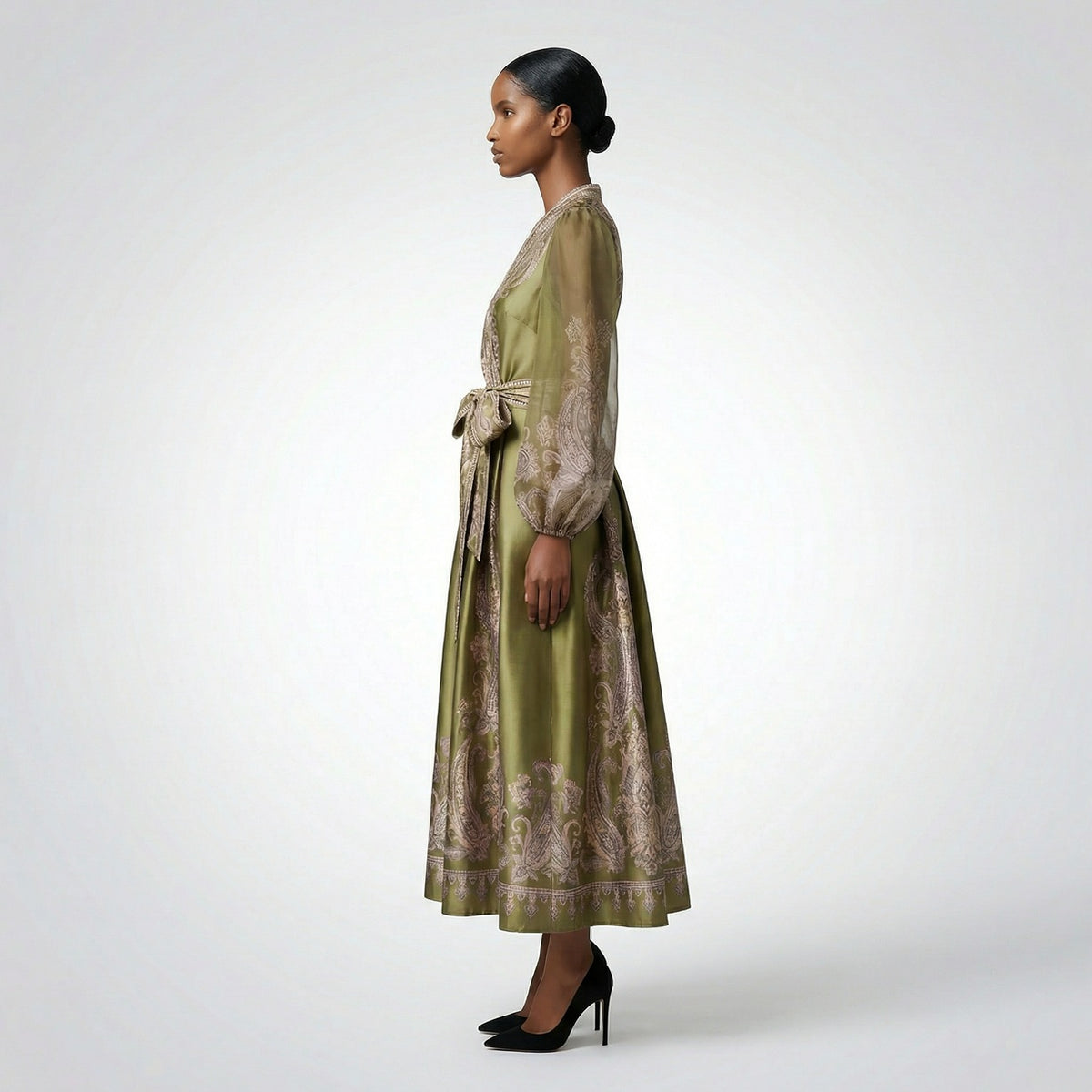 Long-sleeved olive green paisley print maxi dress with a wrap waist and sheer sleeves laid flat.