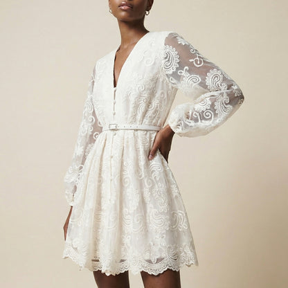woman modeling the Nadia ribbed knit mini dress featuring a long-sleeve bodice and a side-pleated accordion skirt panel.