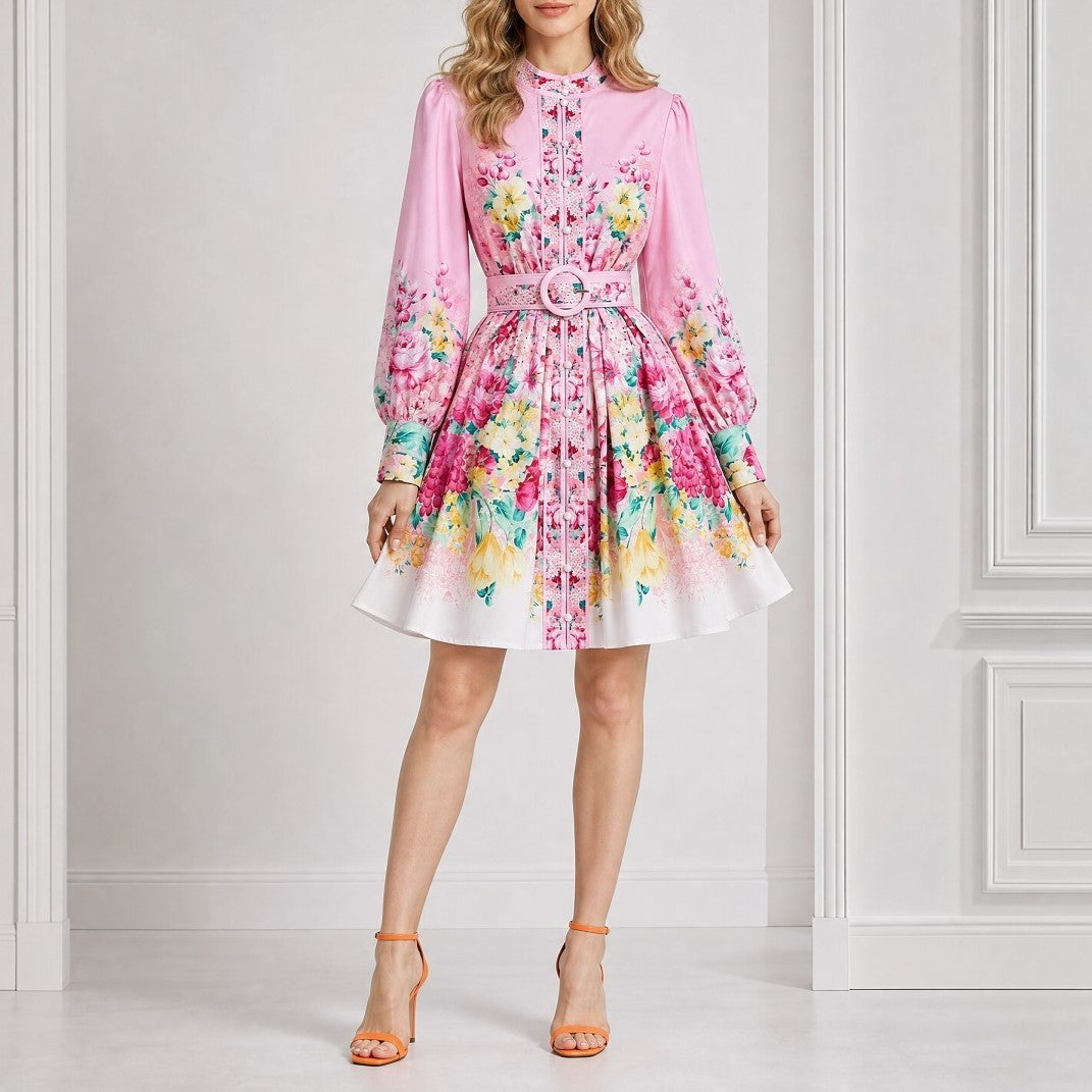 Nandini pink floral mini dress showing the lightweight fabric, high collar, and matching patterned waist belt. pink floral mini dress with an ornate button-down front panel, mandarin collar, and matching eyelet belt.Flat lay display of the airy Nandini floral mini dress with elegant long sleeves and 89 cm (35 inches) hollow to hem length,