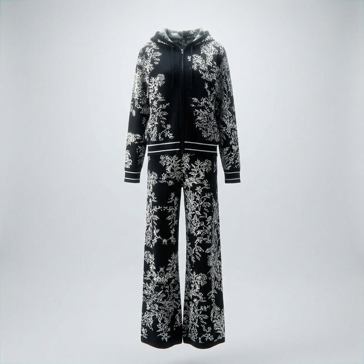 Rafaella two-piece knit tracksuit featuring a black floral jacquard pattern on a grey, cream, black, and beige background.