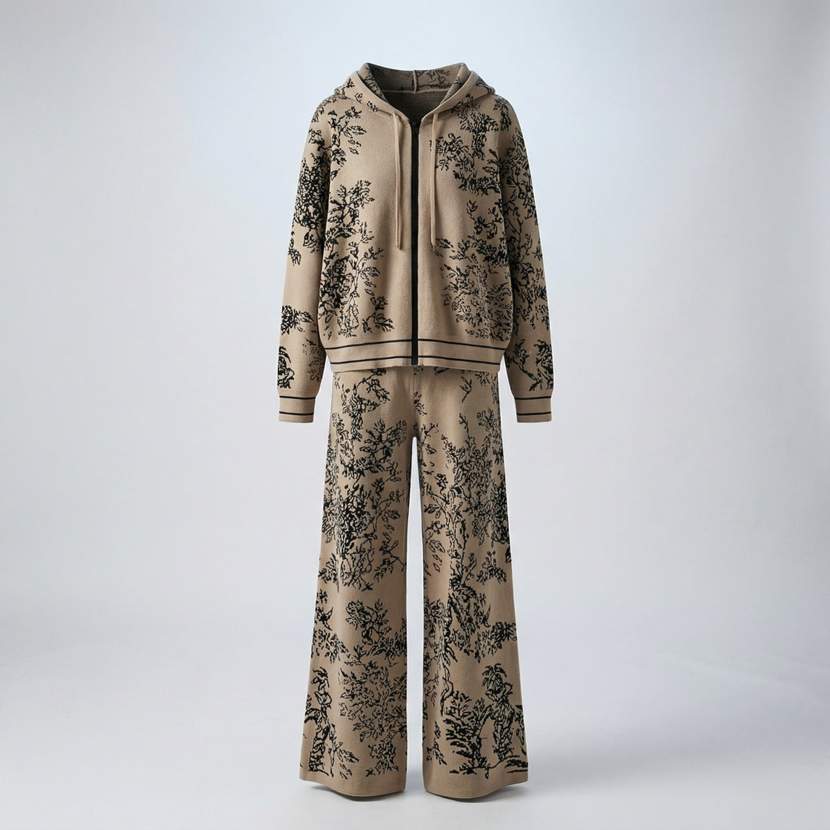 Rafaella two-piece knit tracksuit featuring a black floral jacquard pattern on a grey, cream, black, and beige background.