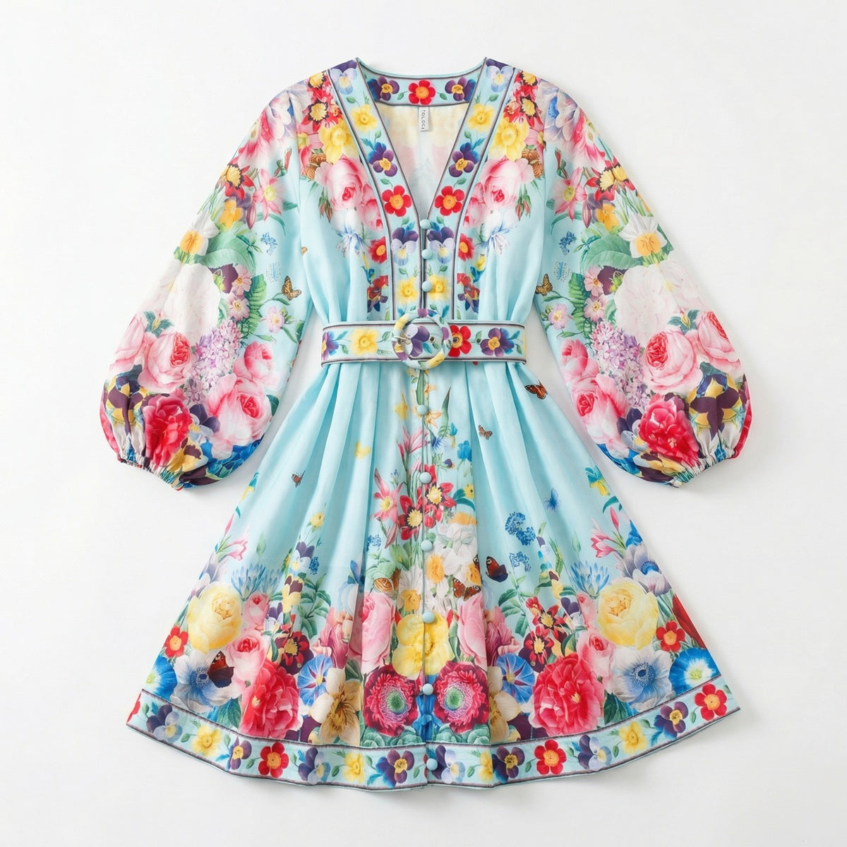 The Rebecca mini dress shown in blue and white featuring a long-sleeved ribbed knit bodice and a dramatic side-pleated accordion skirt with a matching waist belt.