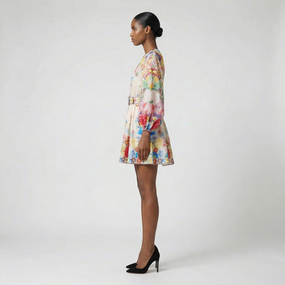 The Rebecca mini dress shown in blue and white featuring a long-sleeved ribbed knit bodice and a dramatic side-pleated accordion skirt with a matching waist belt.