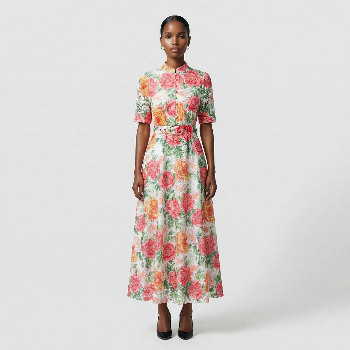 Full length view of the rhona white guipure lace maxi dress with red and orange floral embroidery and matching belt on a grey background.