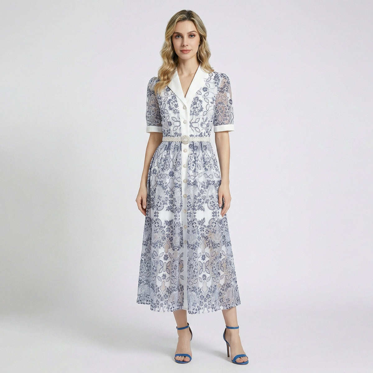 Front view of a woman wearing the Ruxandra navy blue floral lace midi-maxi dress with white lapel and pearl belt.