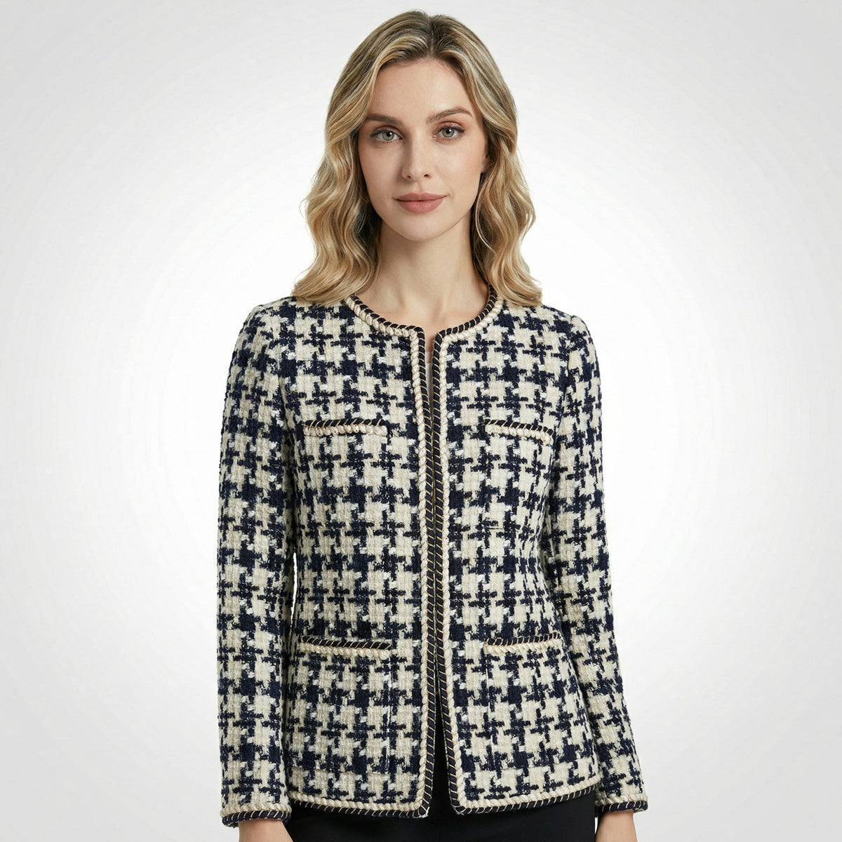 Close-up of Selina navy and cream houndstooth tweed jacket featuring gold braided trim and four front pockets.