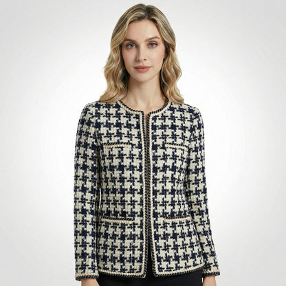 Close-up of Selina navy and cream houndstooth tweed jacket featuring gold braided trim and four front pockets.