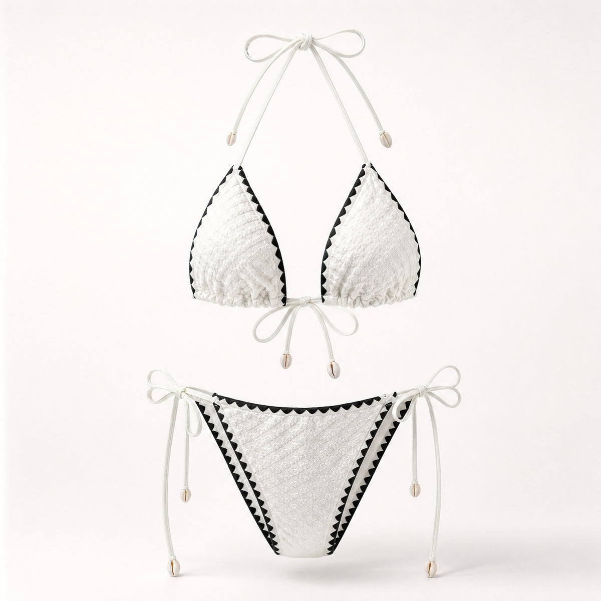 Crisp white popcorn fabric bikini with black contrast trim and shell charms.