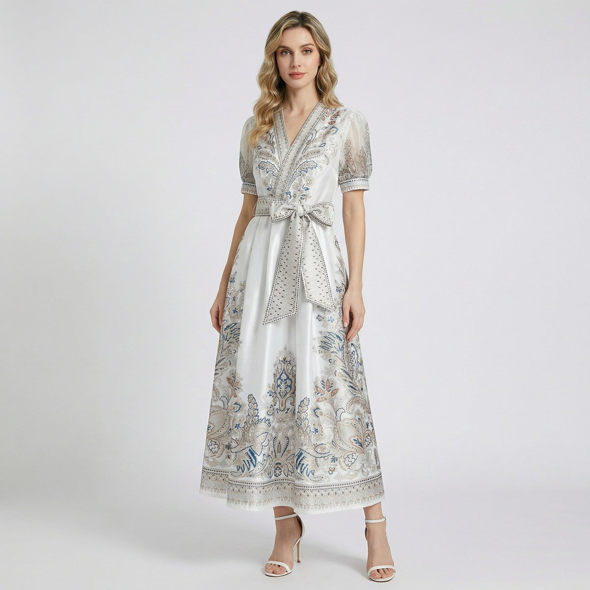 Two Teodora maxi dresses in black and white featuring paisley prints, puff sleeves, and large bow belts.