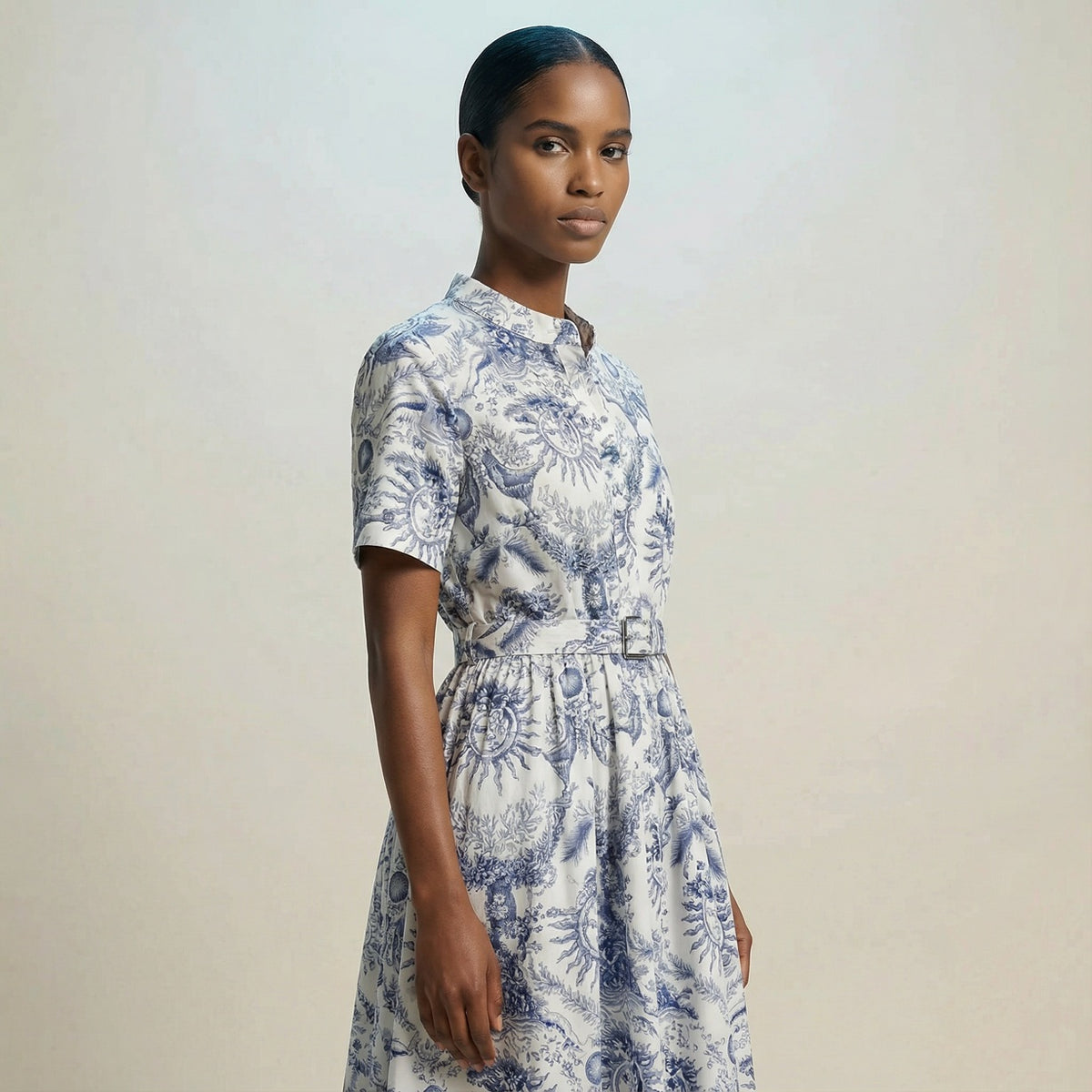 The Veronica midi dress featuring a short-sleeved ribbed knit bodice and a side-pleated accordion skirt with a matching waist belt.